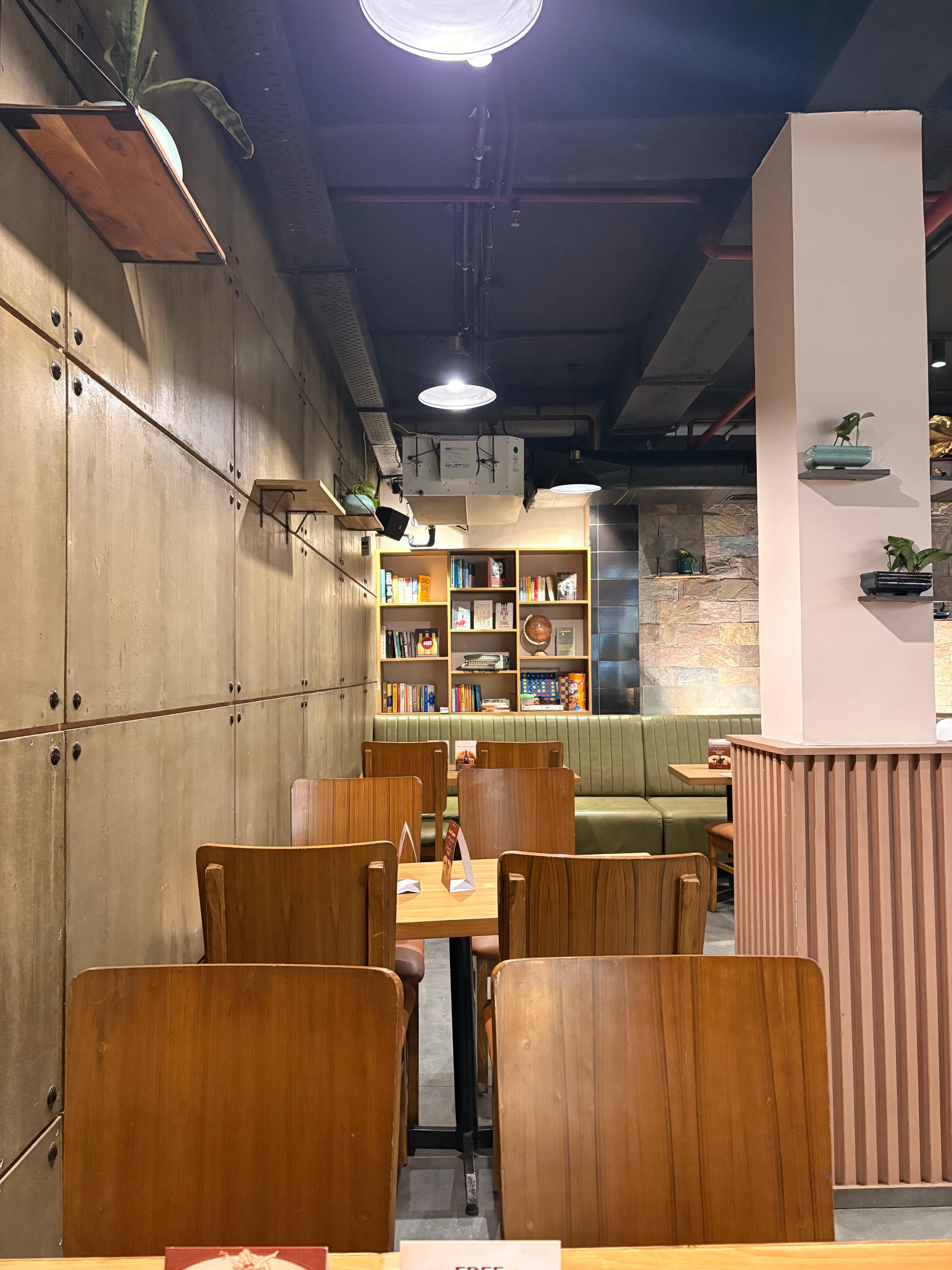 Industrial-warm interior with bookshelves, banquettes and a quiet corner